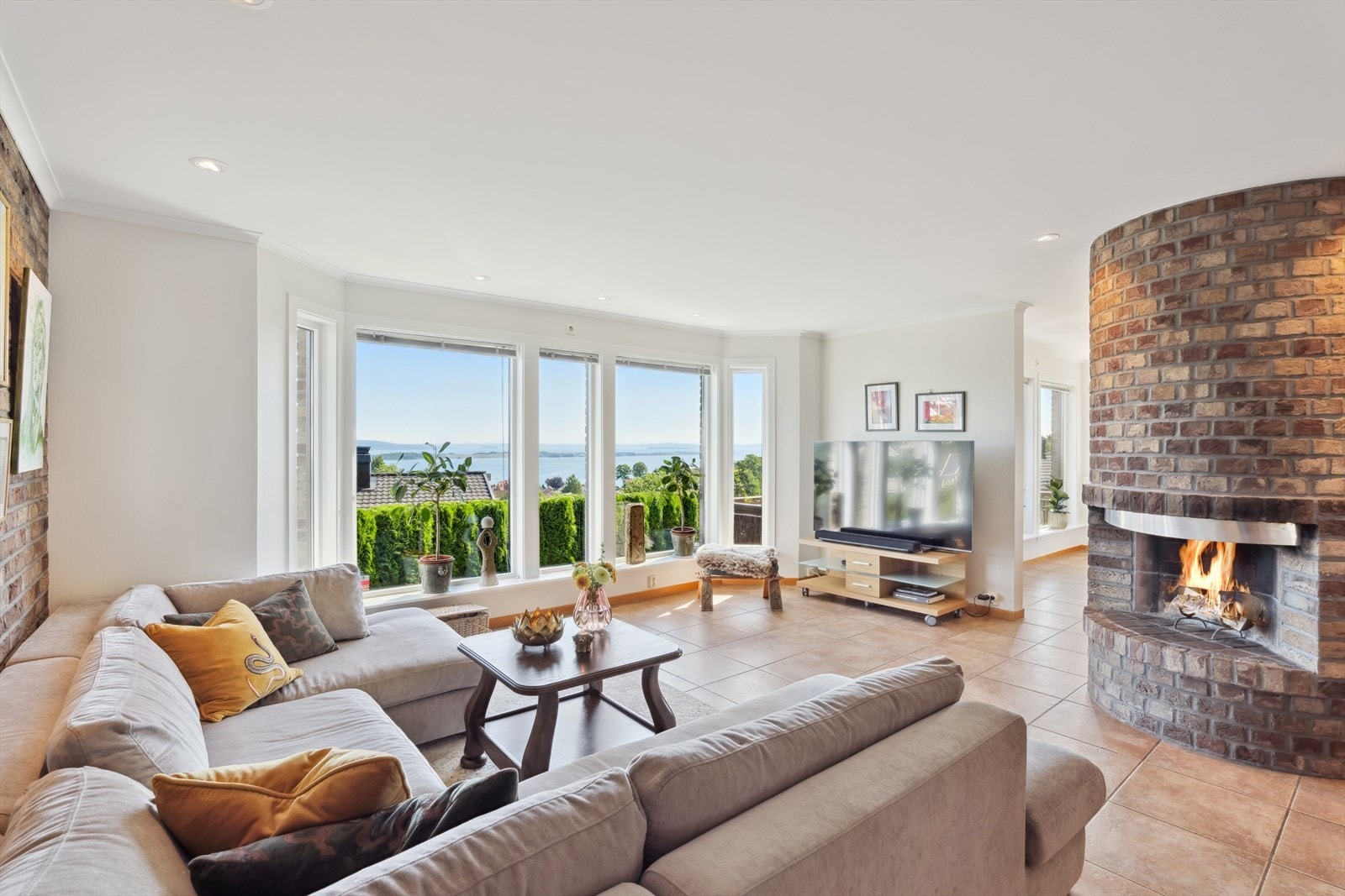 Boligen har en lys og stor stue med hyggelig peis og flott sjøutsikt Galleribilde