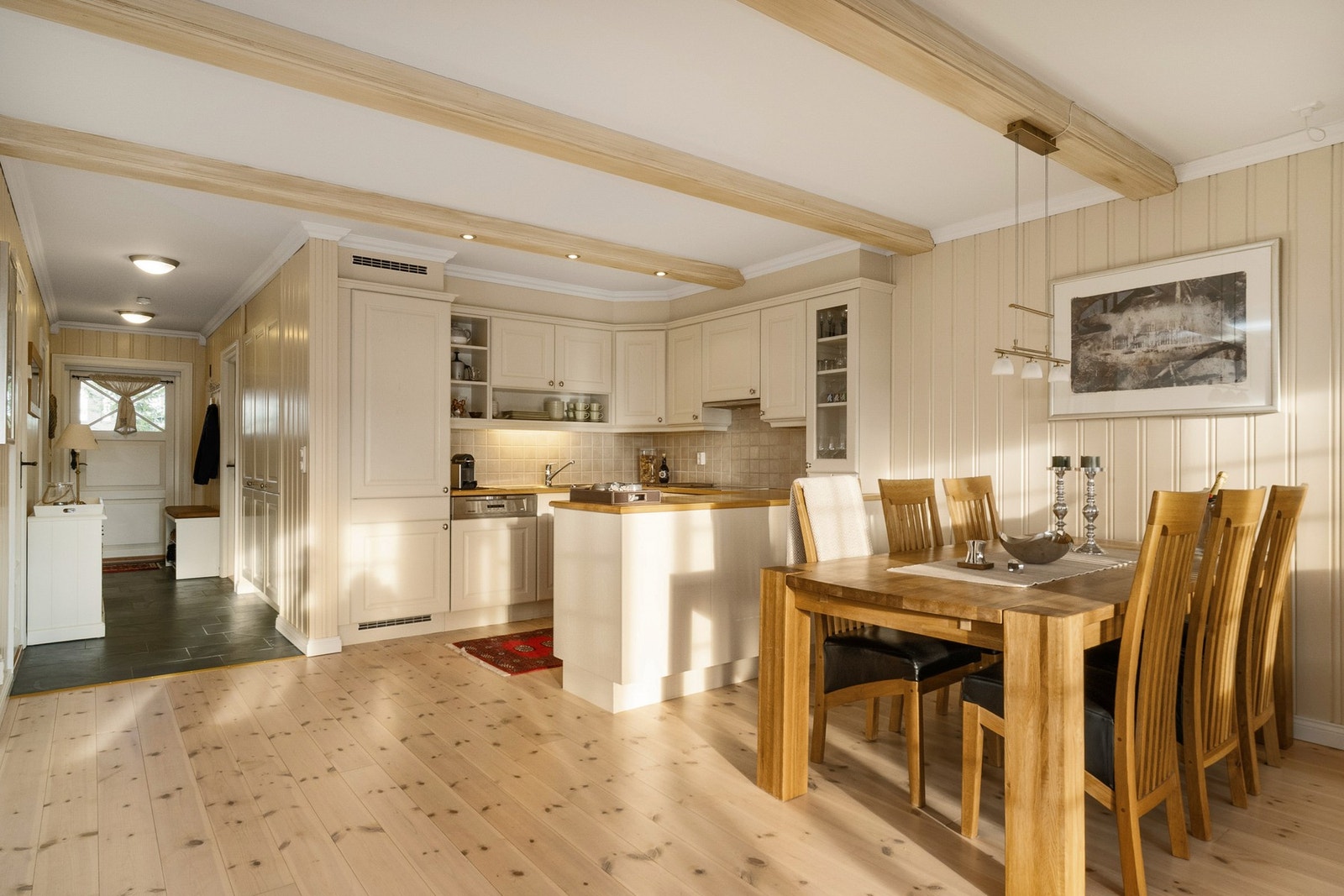 Åpen kjøkkenløsning med innredning i klassisk stil og profilerte fronter. Galleribilde