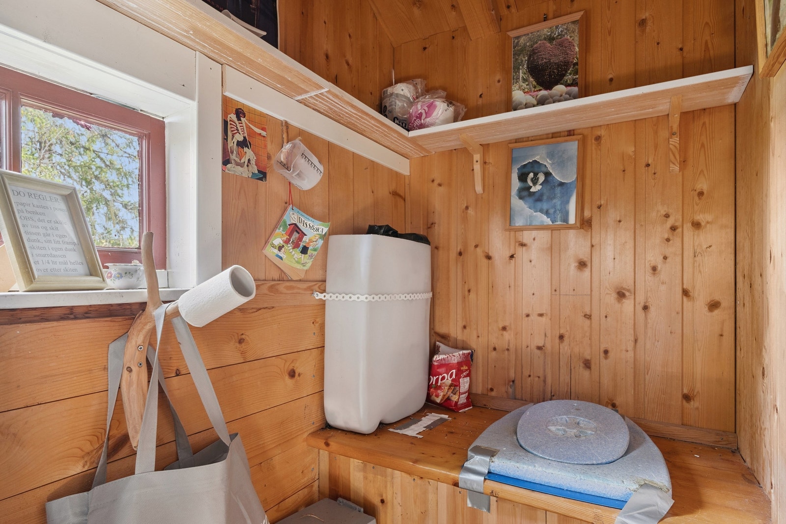 Inne i uthuset finner man en bod og en tradisjonell utedo. Galleribilde