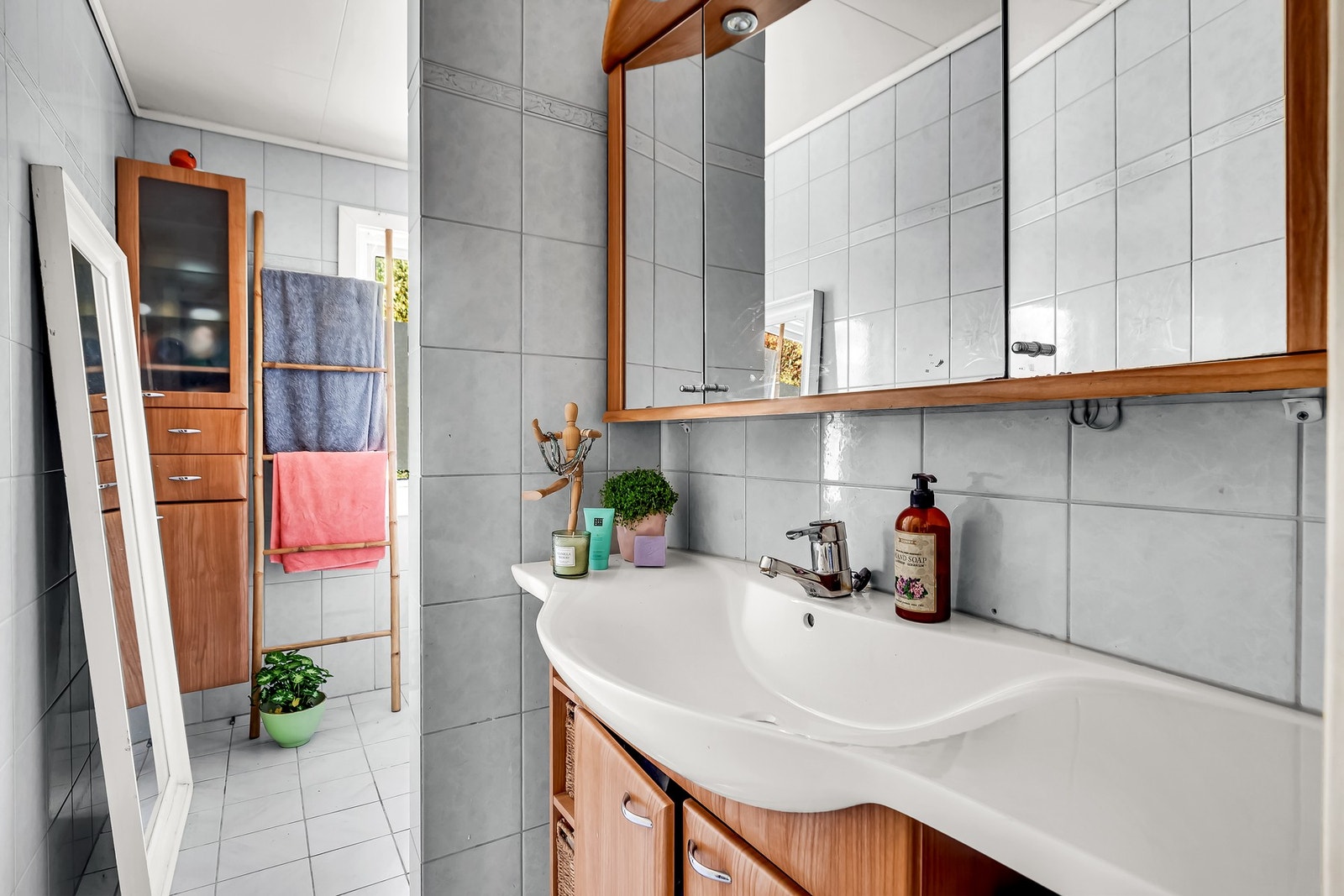 Bad med fliser, gulvvarme og badekar - en praktisk løsning for hele familien Galleribilde