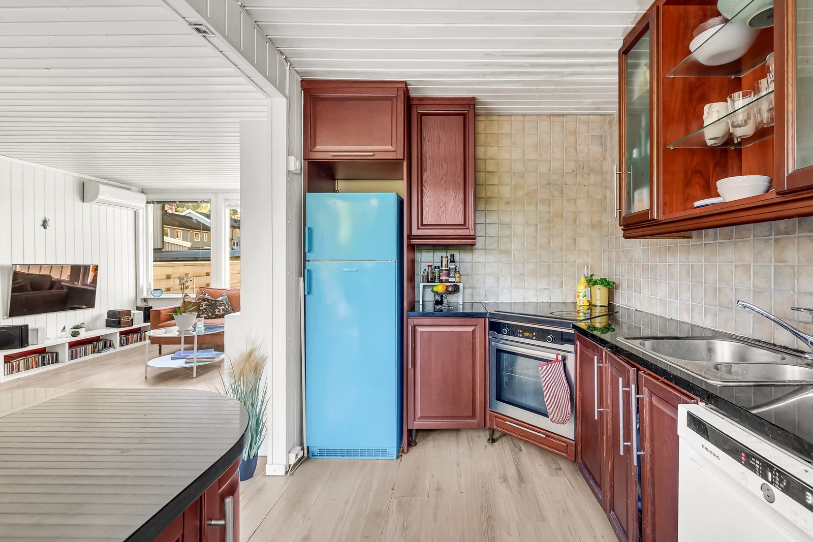 Åpen kjøkkenløsning med steinbenkeplate, integrerte hvitevarer og god arbeidsplass Galleribilde