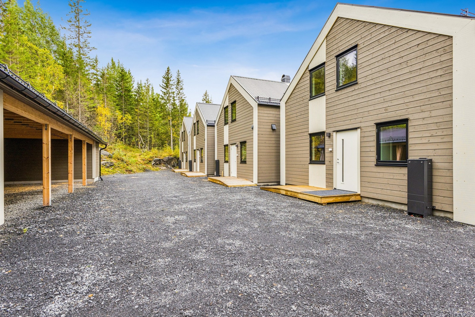 Innkjørselen til sameiet er av gruset standard, planert med plass til gjesteparkering og tilhørende carporter. Galleribilde