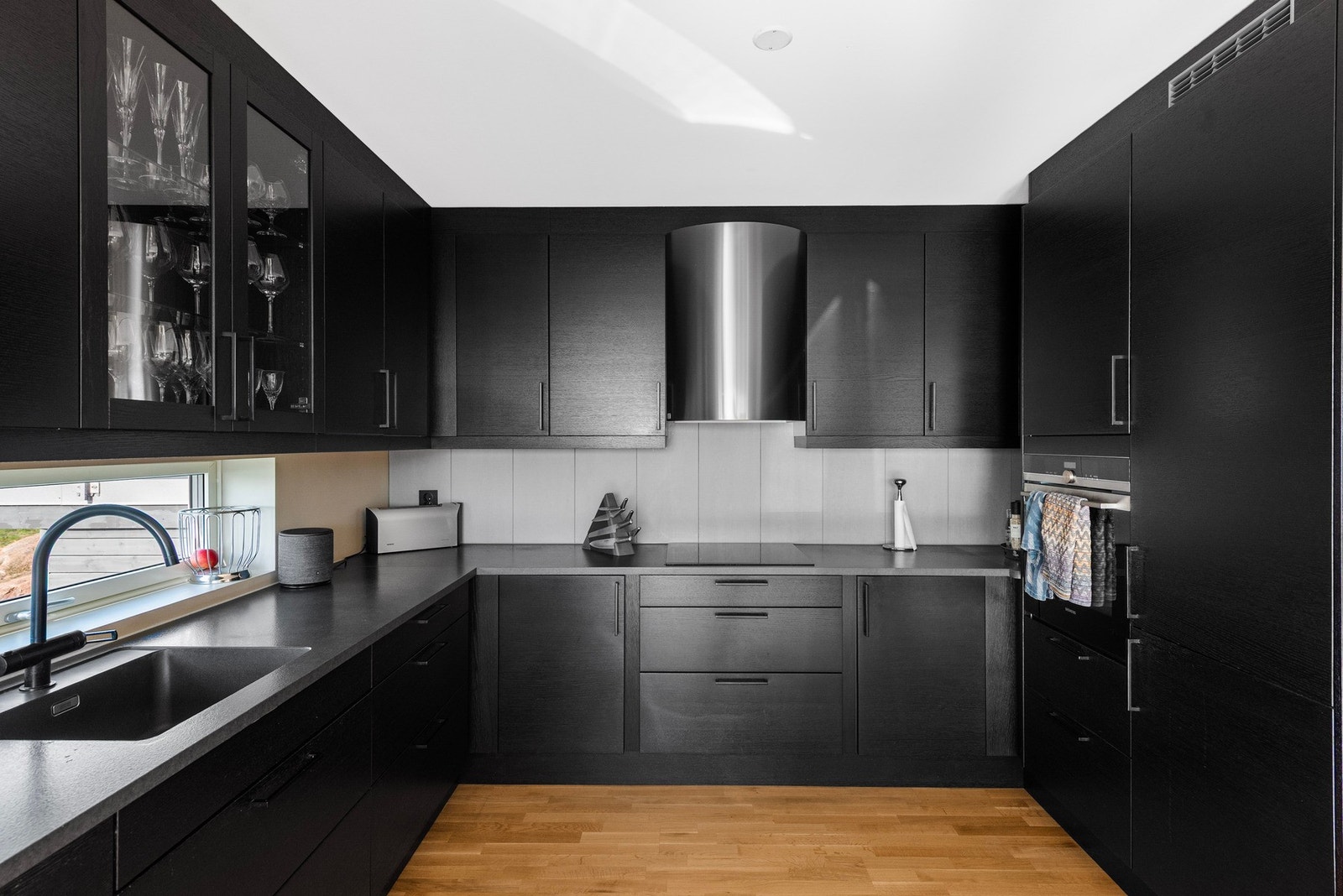 En moderne og mørk innredning med god skap- og benkplass og alle hvitevarer integrert Galleribilde