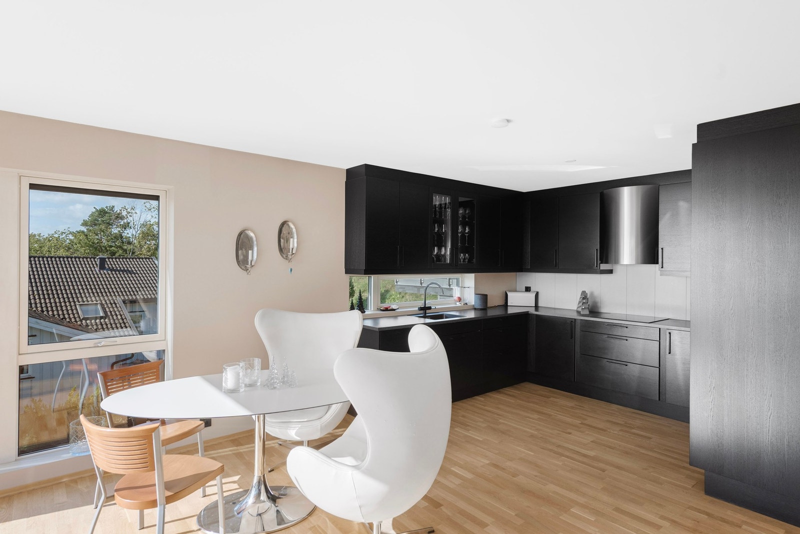 Den mørke kjøkkeninnredningen skaper en elegant kontrast og definerer kjøkkenområdet i det lyse og åpne rommet Galleribilde