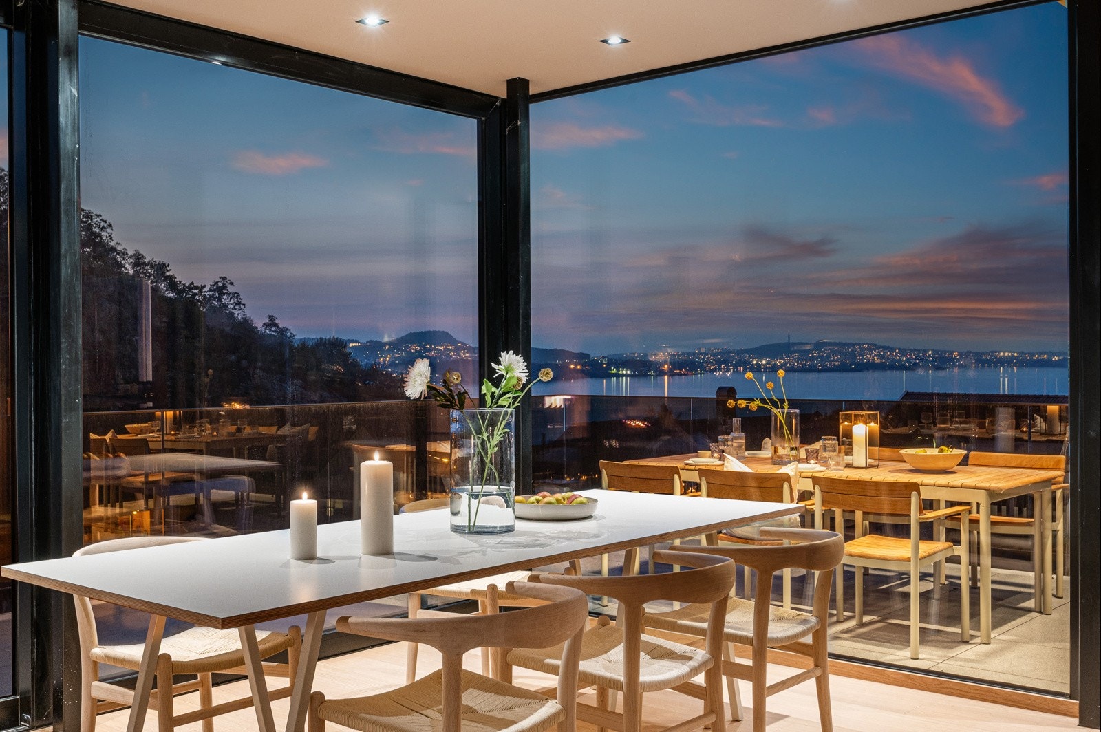 Utsikt fra stue/spisestue i skumring. Utsikten og lyssettingen inne i huset gir en unik og lun atmosfære på kveldstid. Galleribilde