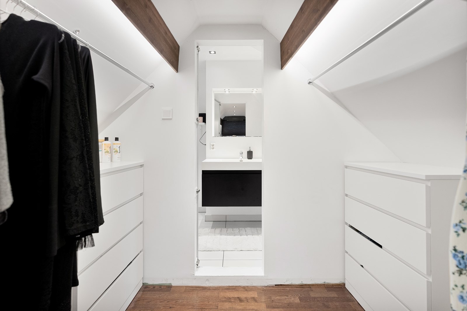 Lys og romslig walk-in garderobe med praktisk oppbevaring og tilknytning til moderne bad. Perfekt for organisering Galleribilde