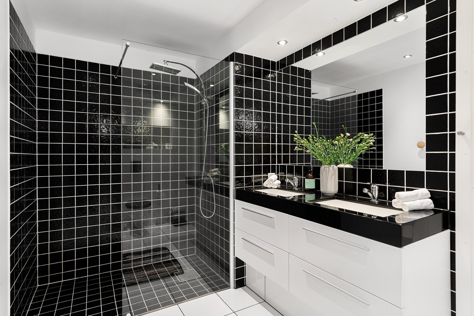 Moderne og stilrent bad med elegant sort flisdesign. Romslig dusjløsning og dobbel servant for optimal komfort. Perfekt for en moderne livsstil. Galleribilde