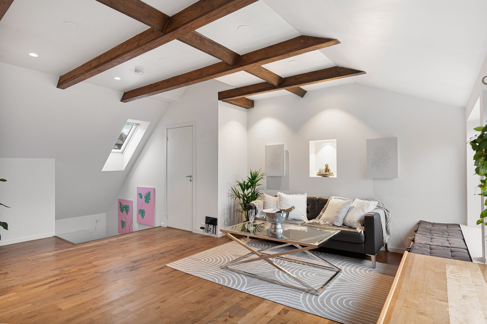 Lys og moderne stue med synlige trebjelker i taket, store vindusflater Galleribilde