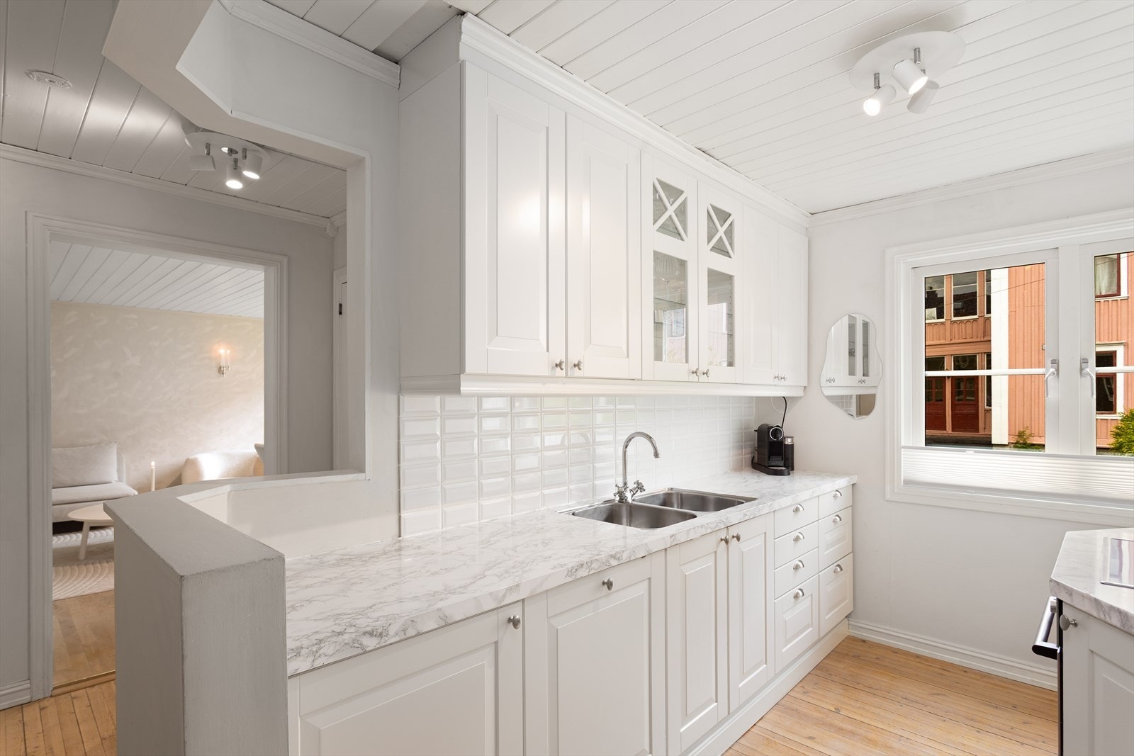 Det er lagt fliser mellom overskap og benkeplate samt foliert benkeplaten i marmor. Galleribilde