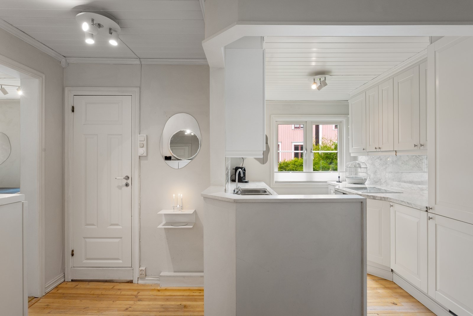 Lyst og stilrent kjøkken - inngang til bad/vaskerom til venstre. Galleribilde