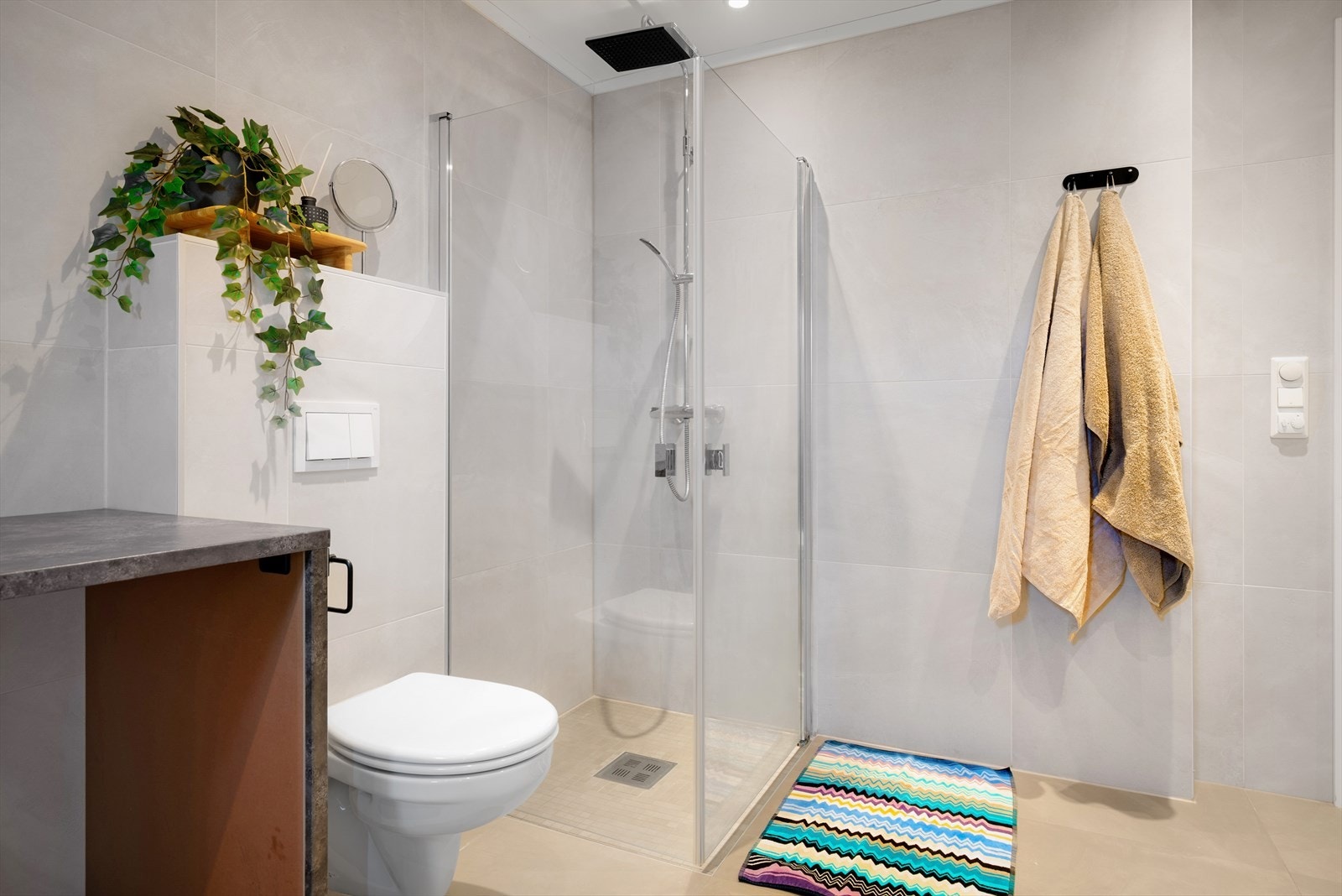 Dusjhjørne med moderne regnfallsdusj og innfellbare glassdører. Galleribilde