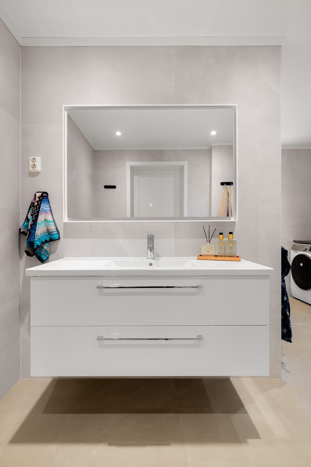 Stilren servantinnredning med store skuffer og speil med integrert belysning. Galleribilde