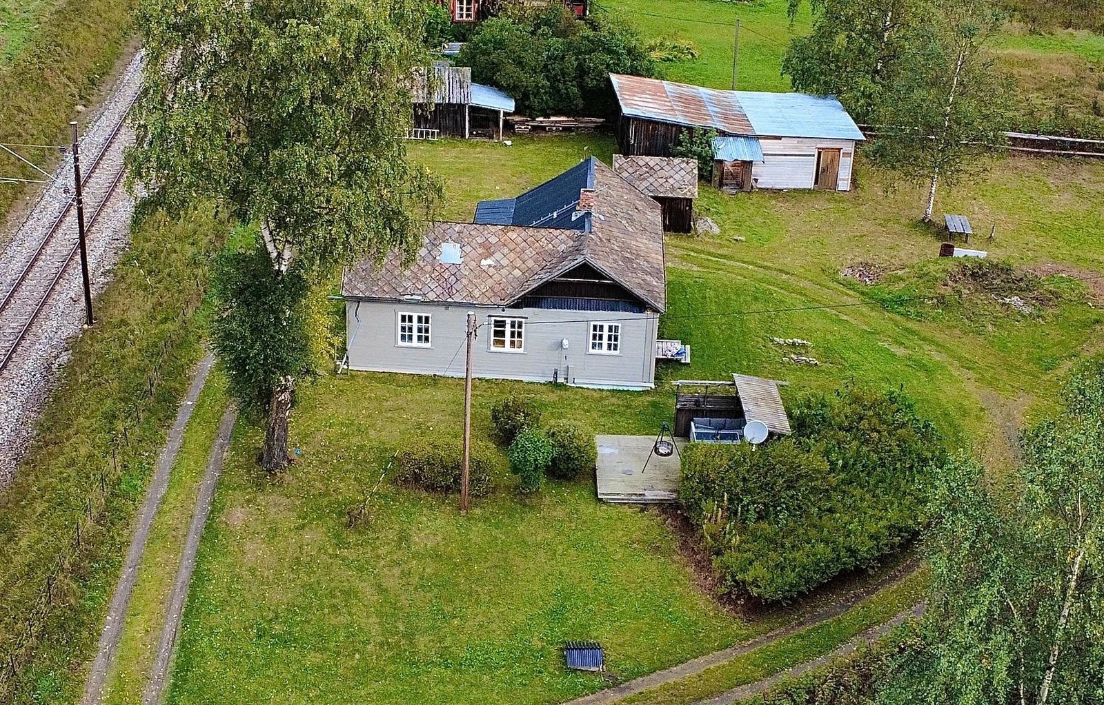 Eiendommen sett i fra sørsiden med opparbeidet hage og platning. Galleribilde