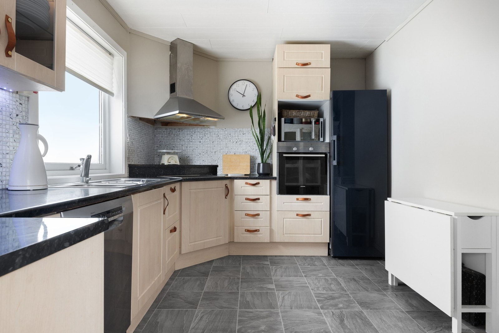 Kjøkkeninnredning med profilert fronter og benkeplate av laminat, med delvis integrerte hvitevarer Galleribilde