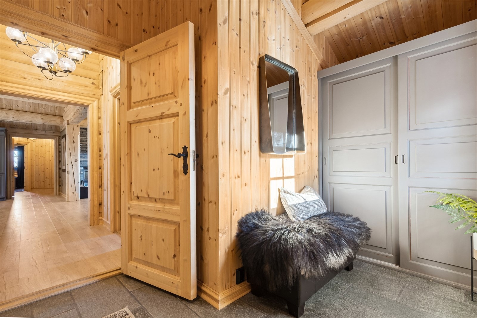 Fritidsboligen har en romslig entré på 6,5 m². Her finnes også et plassbygd skyvedørsgarderobeskap som gir gode oppbevaringsmuligheter. Galleribilde