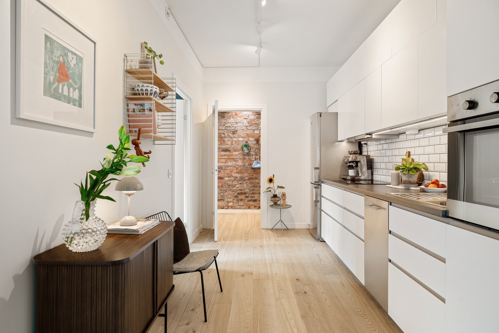 Delvis åpen stue- og kjøkkenløsning med kjøkkeninnredning i egen sone. Galleribilde