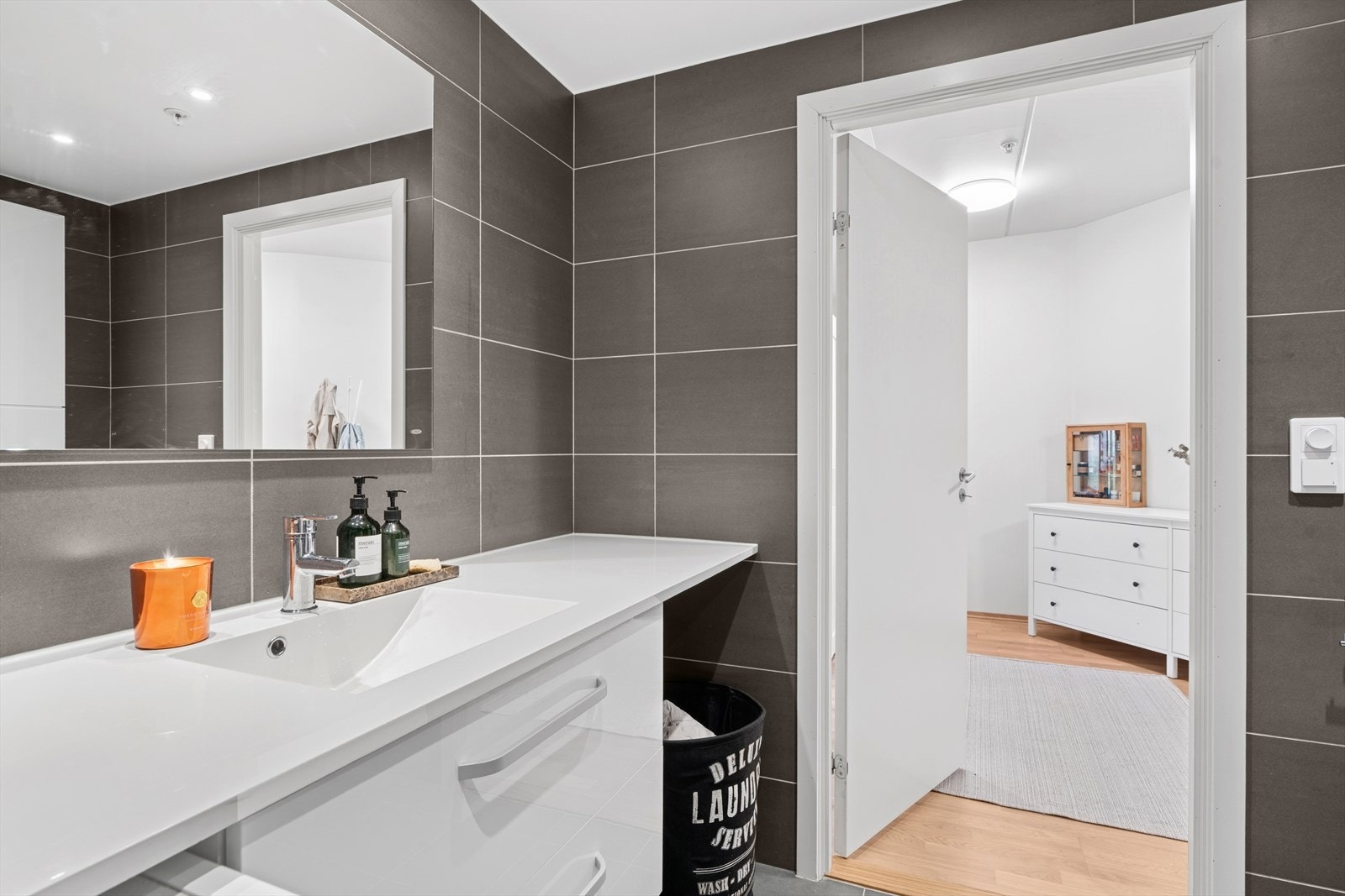 Badet er utstyrt med bl.a. innfellbare dusjdører, servant, vegghengt klosett og opplegg for vaskemaskin og tørketrommel. Galleribilde