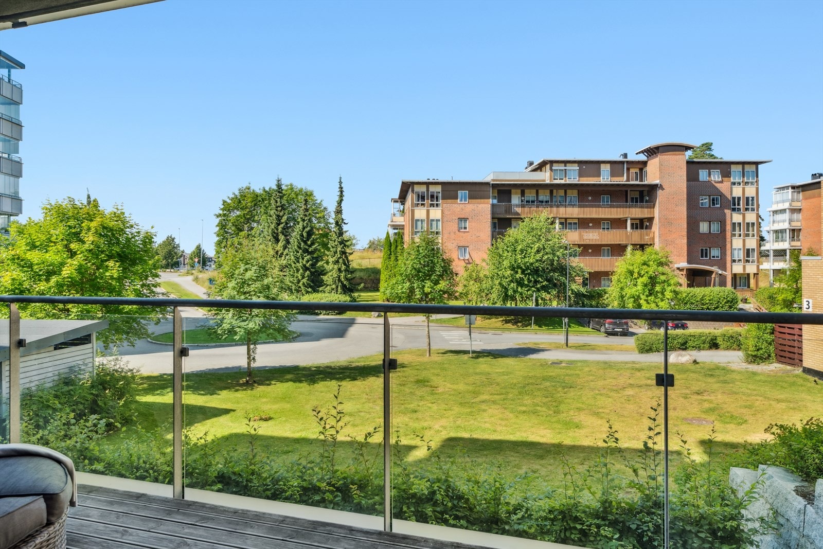 Utsikt mot pent grøntareal fra balkongen. Galleribilde