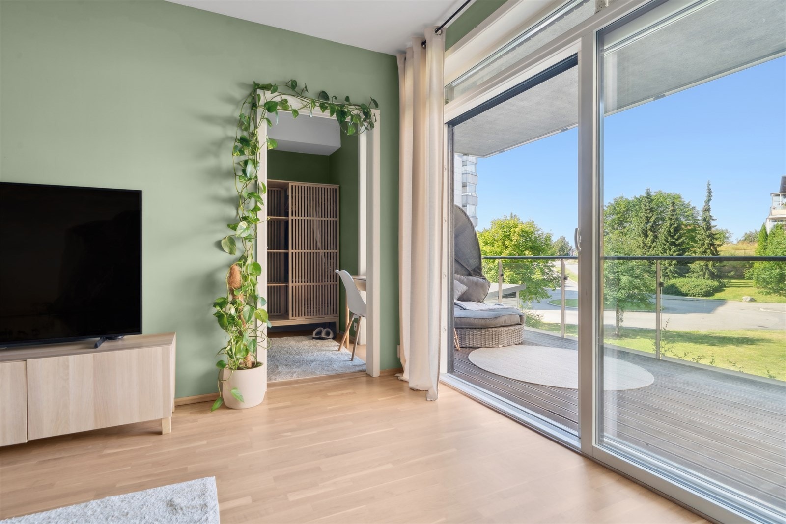 Store skyvedører i glass sørger for godt med lys i leiligheten. Galleribilde