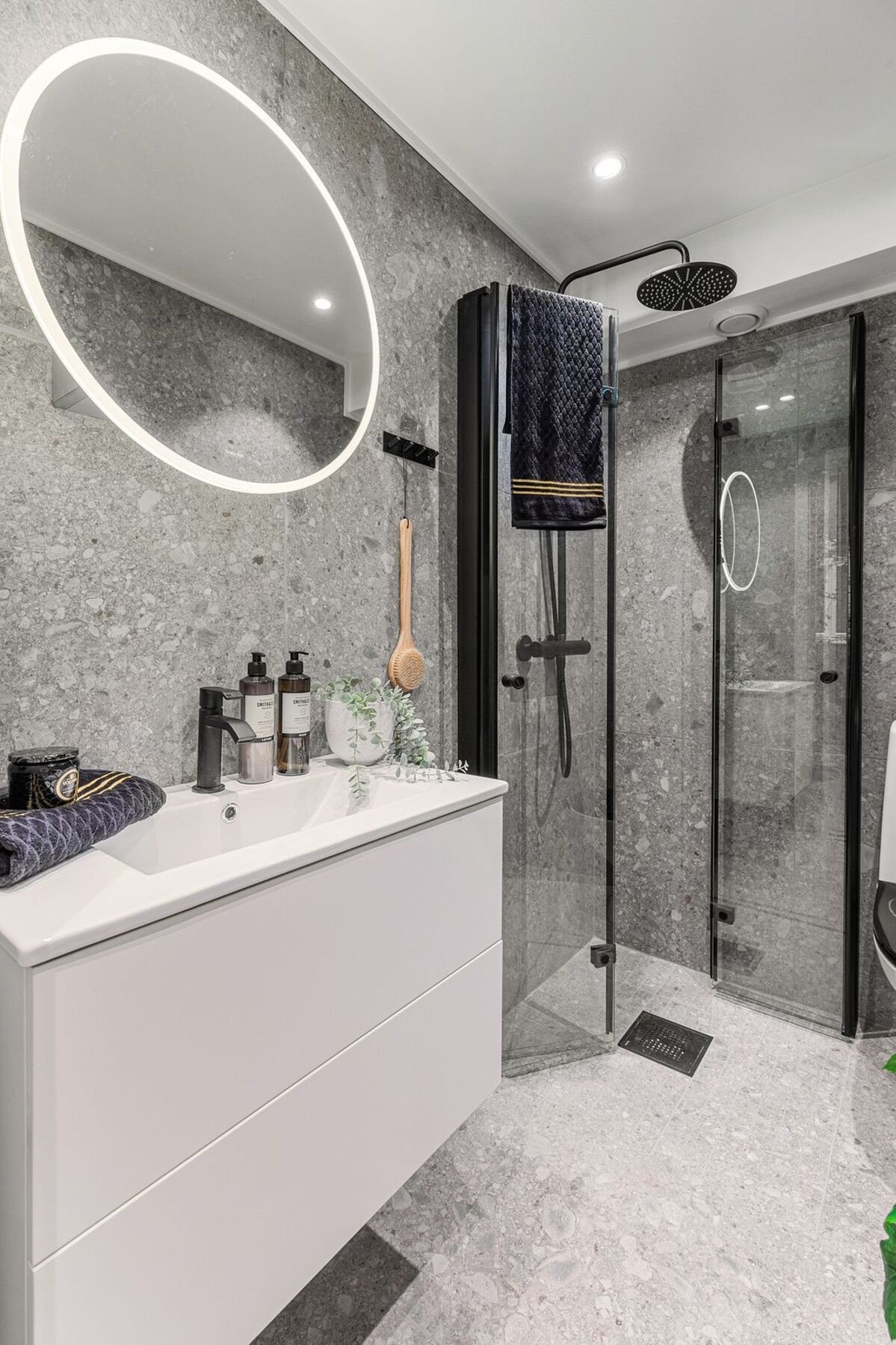 Servantinnredning med folierte glatte fronter og heldekkende servant. Dusjhjørne med svingbare rette leddede dører, termostatstyrt dusjbatteri, regnfallsdusj og dusjutstyr. Galleribilde