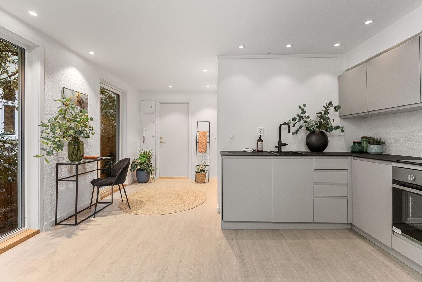 Kjøkkeninnredningen har glatte folierte fronter, kompaktlaminat benkeplate med nedfelt kum i kompositt fra Grohe og armatur fra Tapwell. Galleribilde