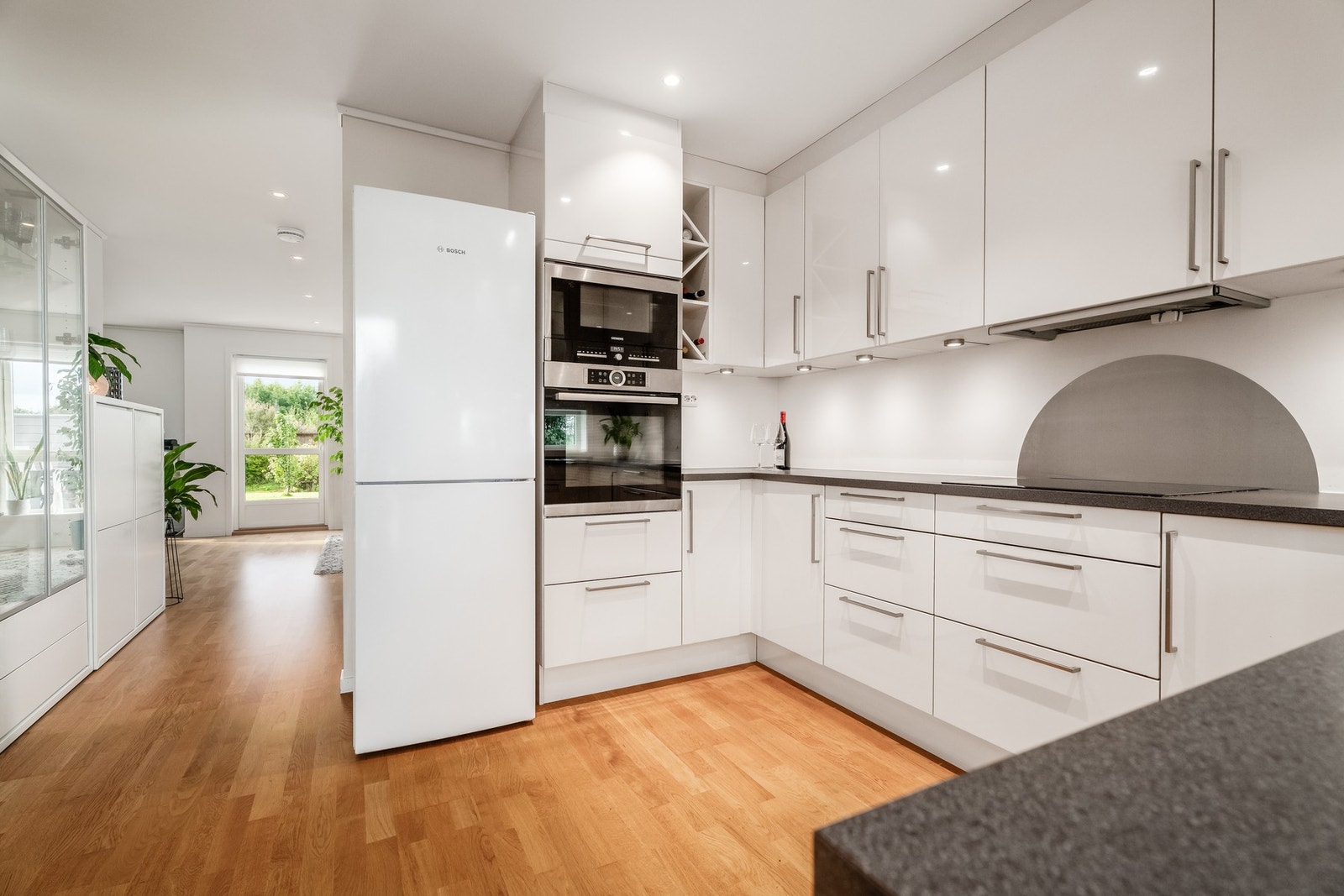 Pent og tidløst kjøkken med hvite, glatte fronter. Laminat benkeplate Galleribilde