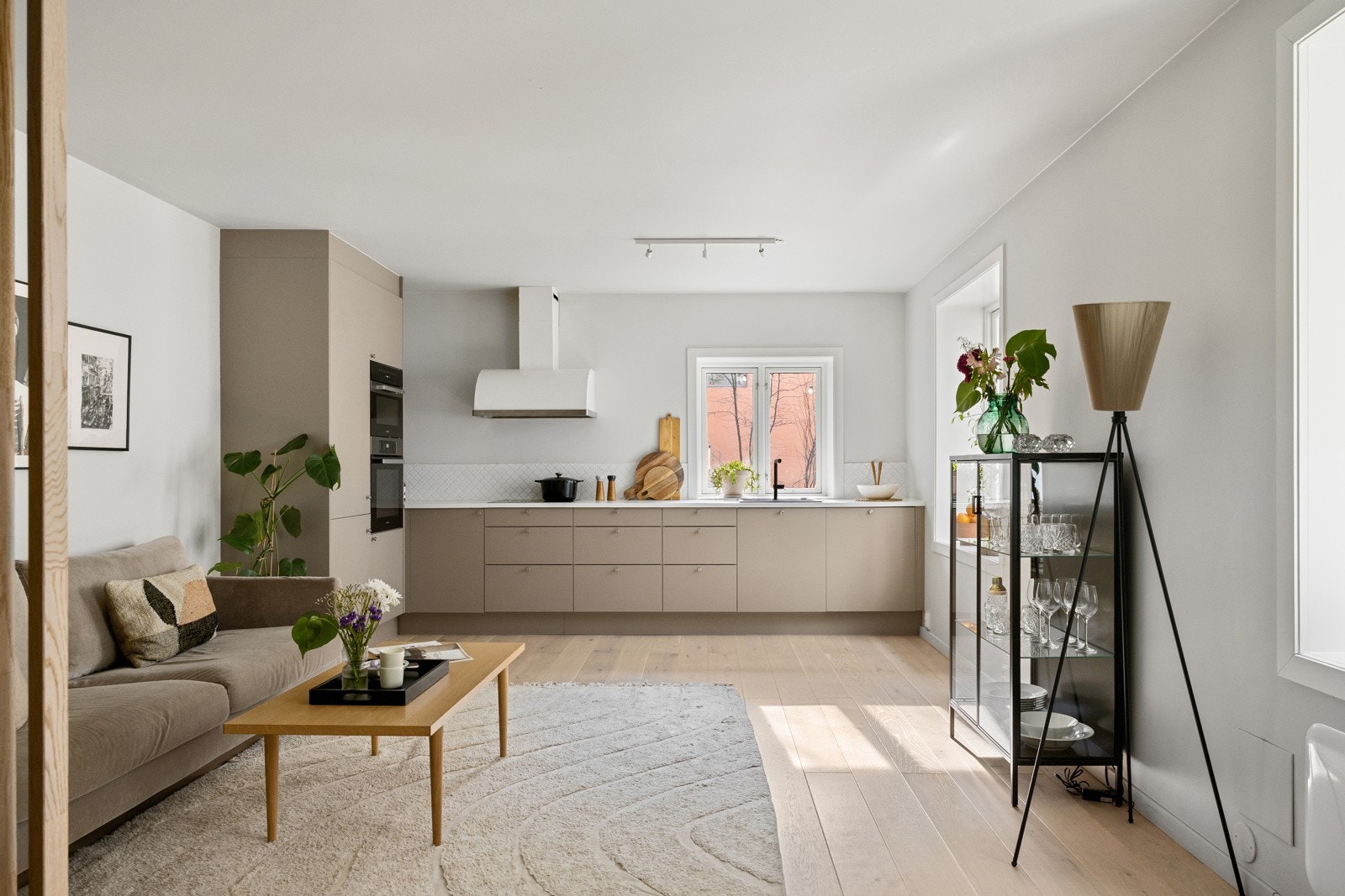 Stilren kjøkkeninnredning fra HTH (2021) med slette fronter i åpen løsning mot stuen - Flere vindusflater bidrar til godt med naturlig lys i boligen! Galleribilde