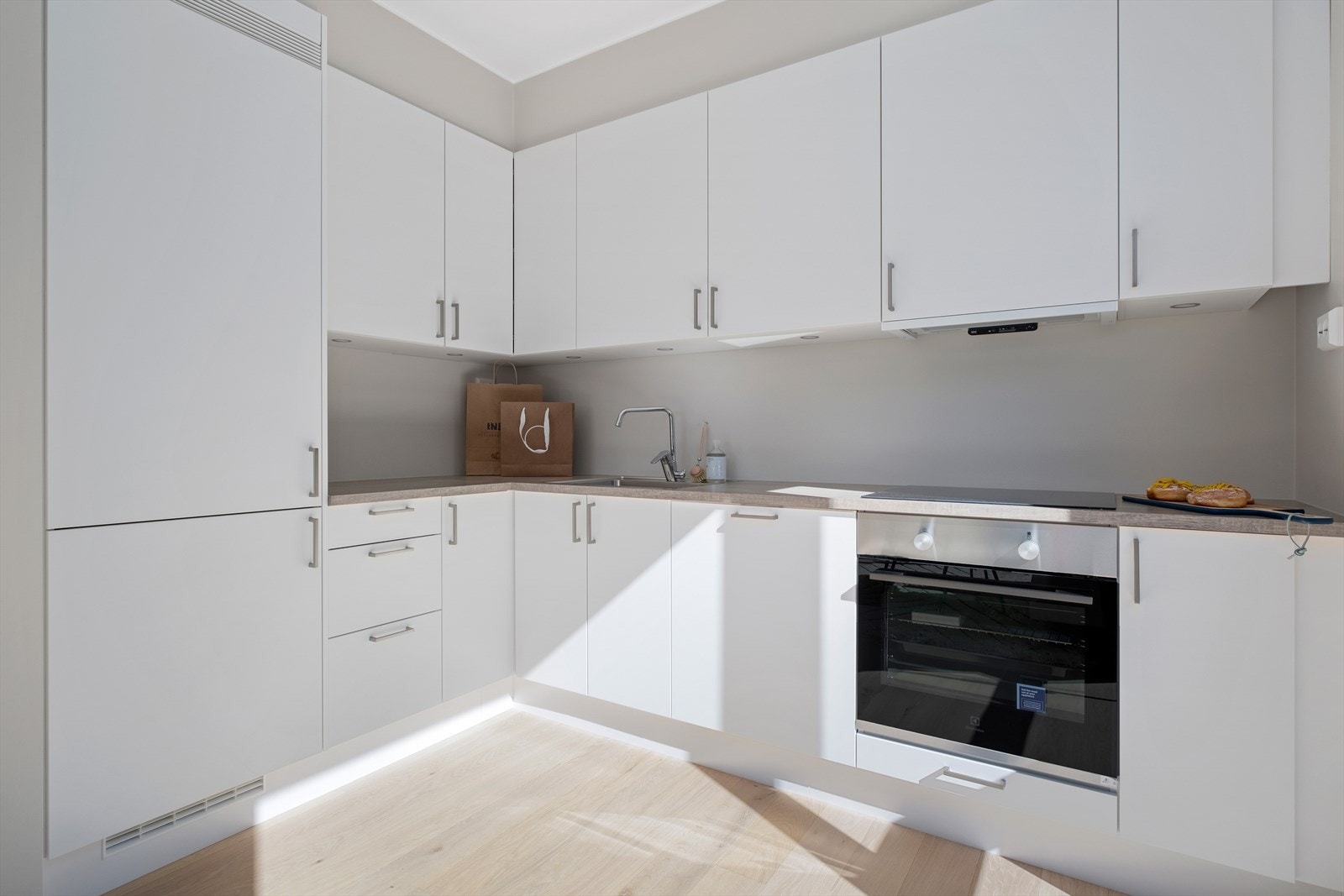 Kjøkkenet har praktisk hjørneplassering og byr på rikelig oppbevaringsplass i over- og underskap, samt godt med arbeidsflater. Galleribilde