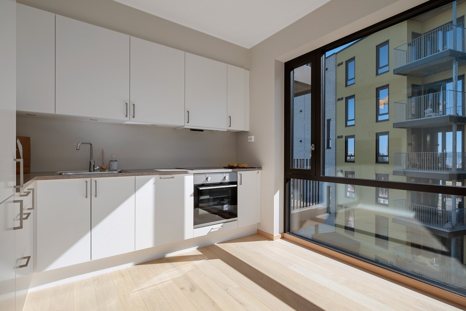 Kjøkkenet byr på integrerte hvitevarer som stekeovn, platetopp, oppvaskmaskin, kombiskap og mekanisk avtrekk over stekesone. Det er også montert spotlights på undersiden av overskapene for elegant belysing. Galleribilde