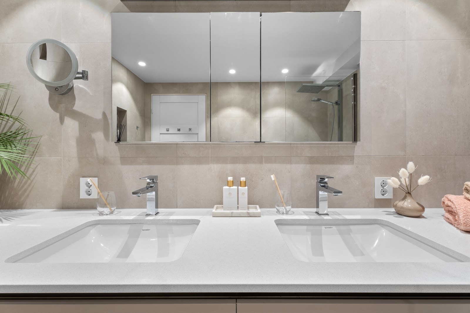 Badet er delikat flislagt og har doble servanter, dusjarmatur med stort regnfallshode og badekar. Galleribilde