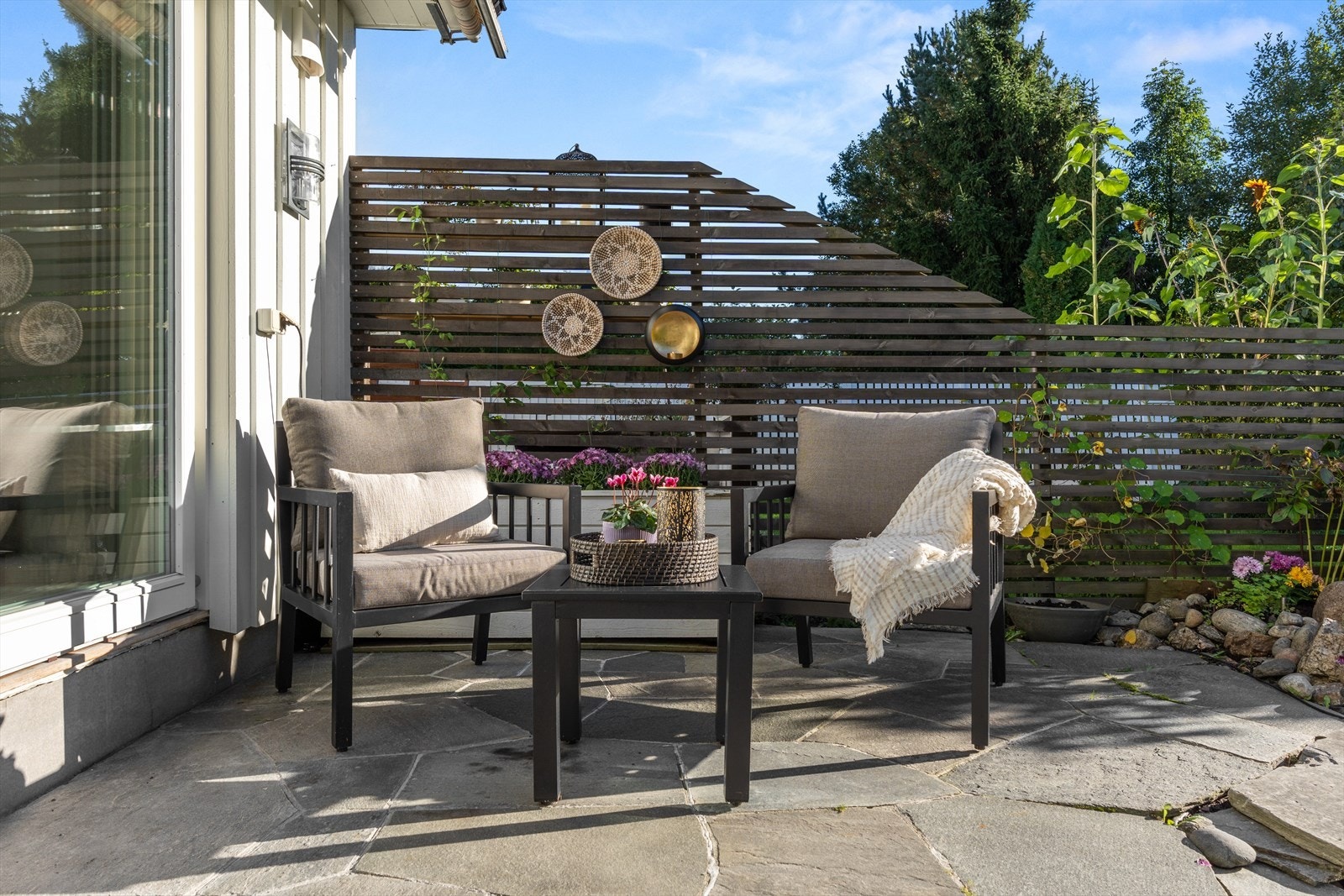 Fra stuen er det direkte utgang til en solrik og steinbelagt uteplass på ca. 22 kvm - perfekt for hyggelige sommerdager. Galleribilde