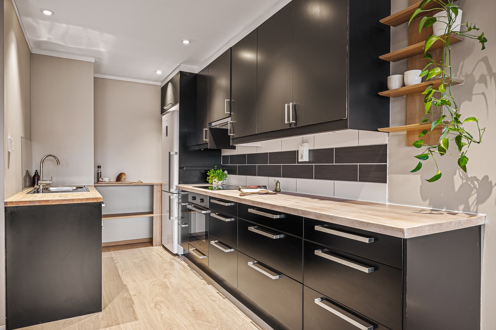Kjøkkeninnredningen er fra IKEA og byr på en kombinasjon av moderne uttrykk og praktiske løsninger, med slette fronter, heltre benkeplate og nedfelt stålvask. Galleribilde