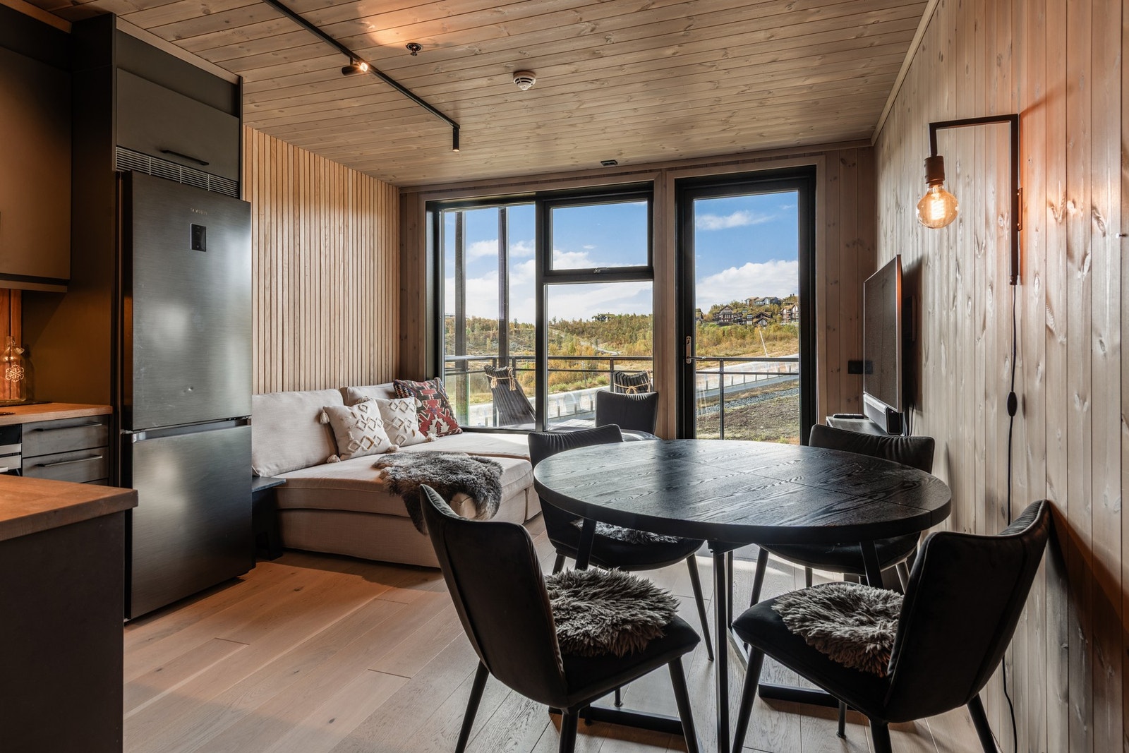 Stue og kjøkken i åpen løsning med utgang til solrik altan Galleribilde