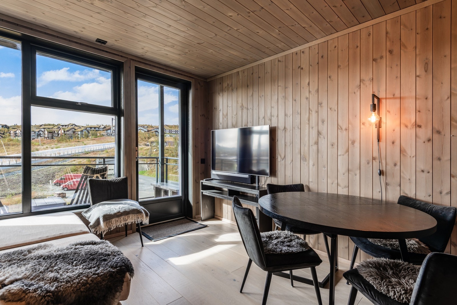 Stue og kjøkken i åpen løsning med utgang til solrik altan Galleribilde