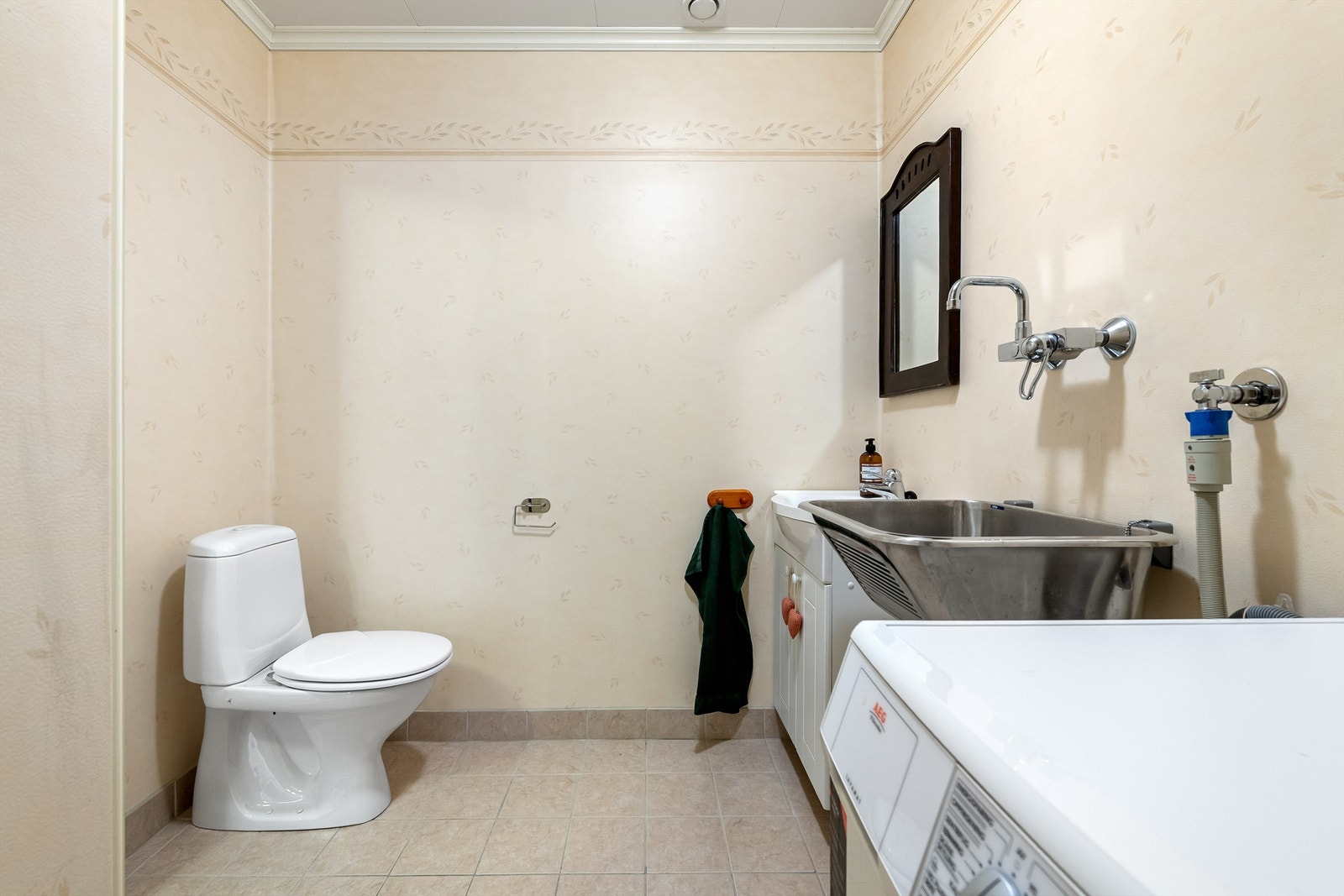 Det er toalett, utslagsvask og opplegg for vaskemaskin på vaskerommet Galleribilde