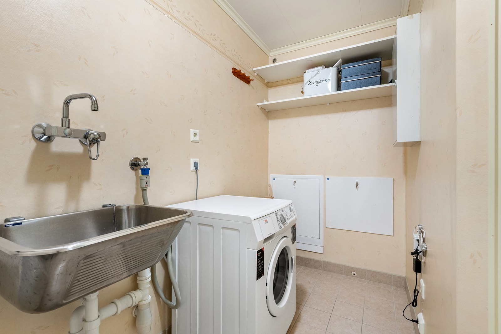 Vaskerommet har fordelerskap for vann og fjernvarme, sikringsskap, ventilasjon i himling. Det er røropplegg for montering av sentralstøvsuger. Galleribilde