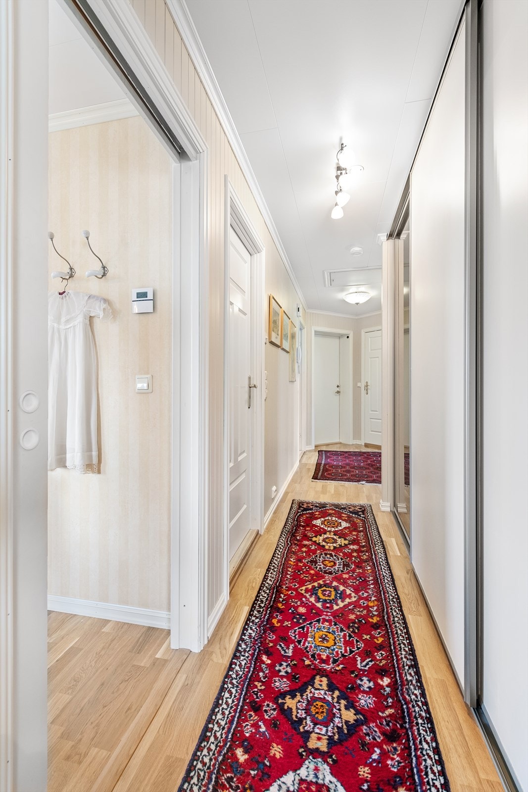 Gang med skyvedørsgarderobe med gode oppbevaringsmuligheter for yttertøy og sko Galleribilde