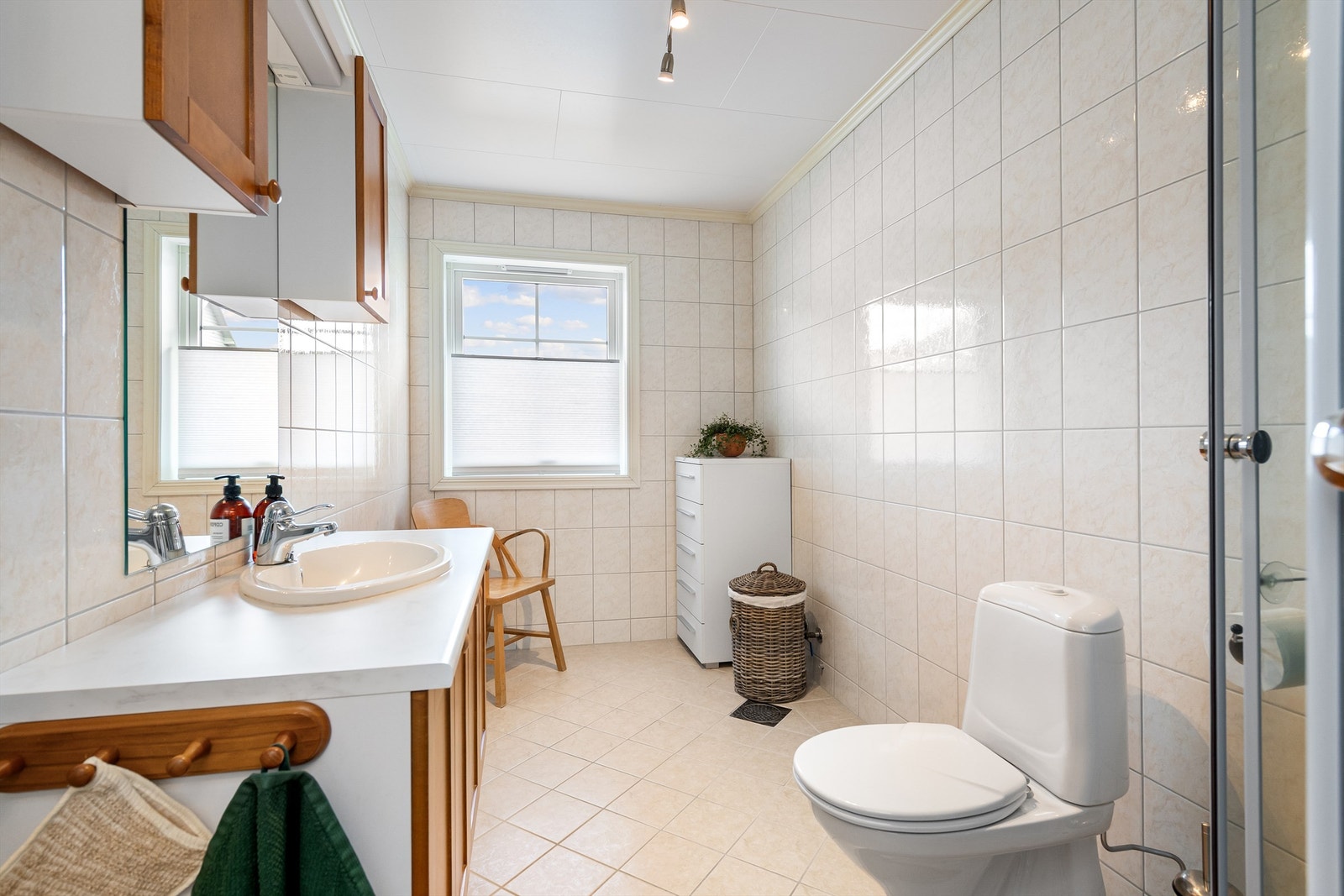 Flislagt gulv med vannbåren gulvvarme, flislagte vegger og malte takplater i tak. Galleribilde