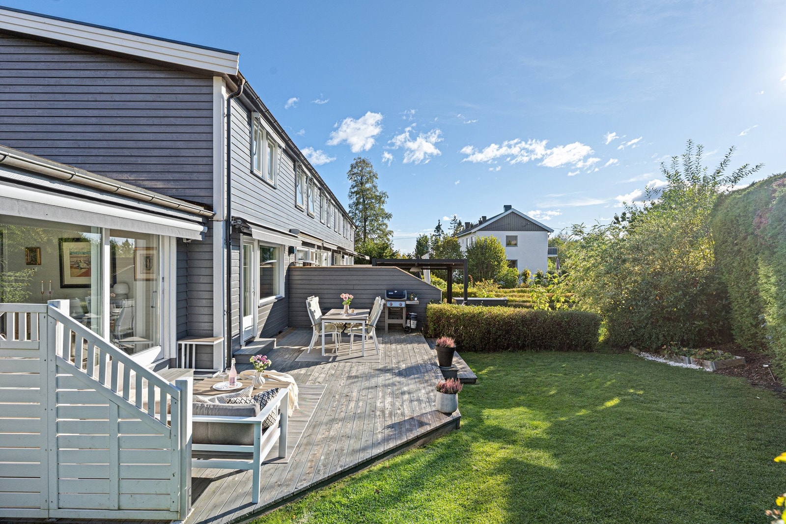 Boligen har en stor, solrik terrasse og hage Galleribilde