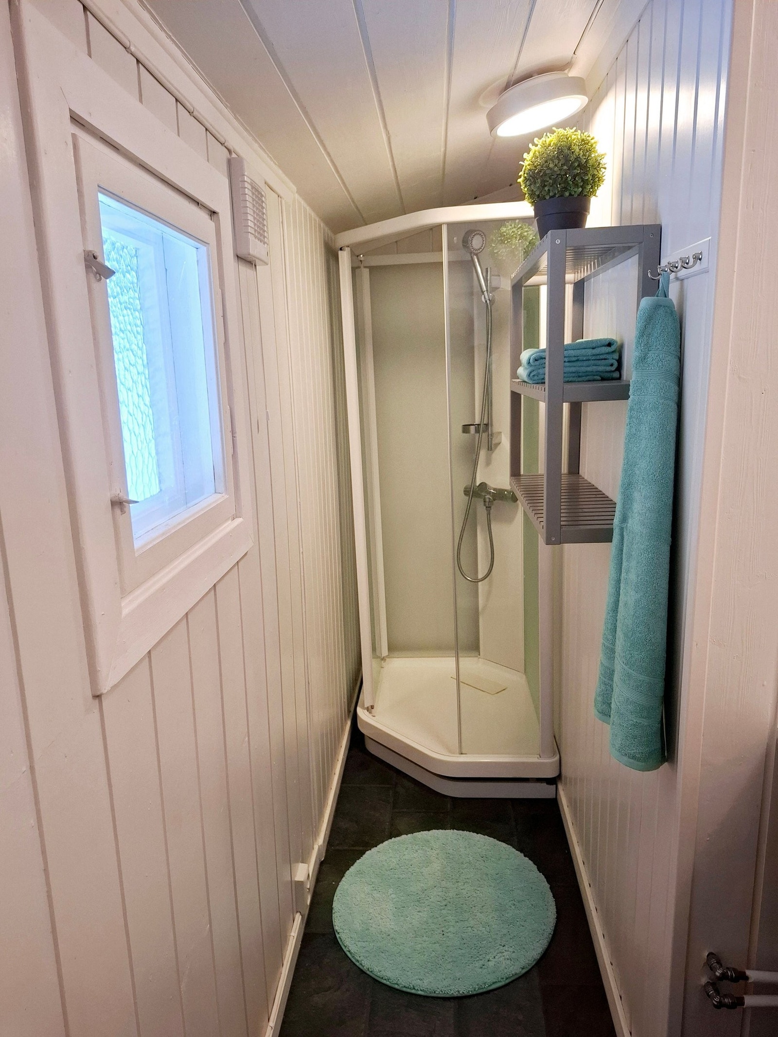 Bad med tilpasset dusjkabinett. Vannet kommer fra en sisterne under hytta. Vanne blir varmet av en hurtig varmtvannsbereder. Galleribilde