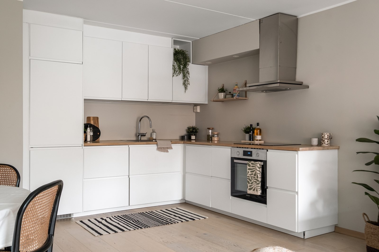 Kjøkkeninnredning med glatte fronter, laminat benkeplate med nedfelt vaskekum og overskap. Galleribilde