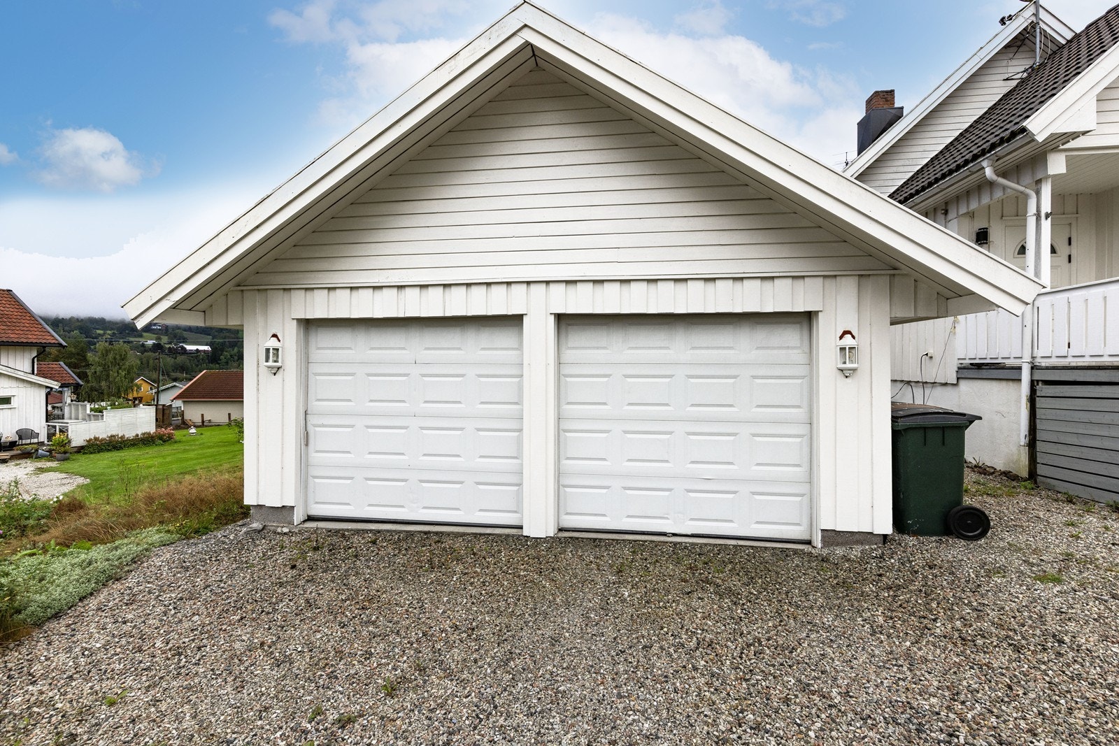 Garasjen gir plass for to biler, samt at det er gode parkeringsmuligheter i gårdsplassen. Galleribilde