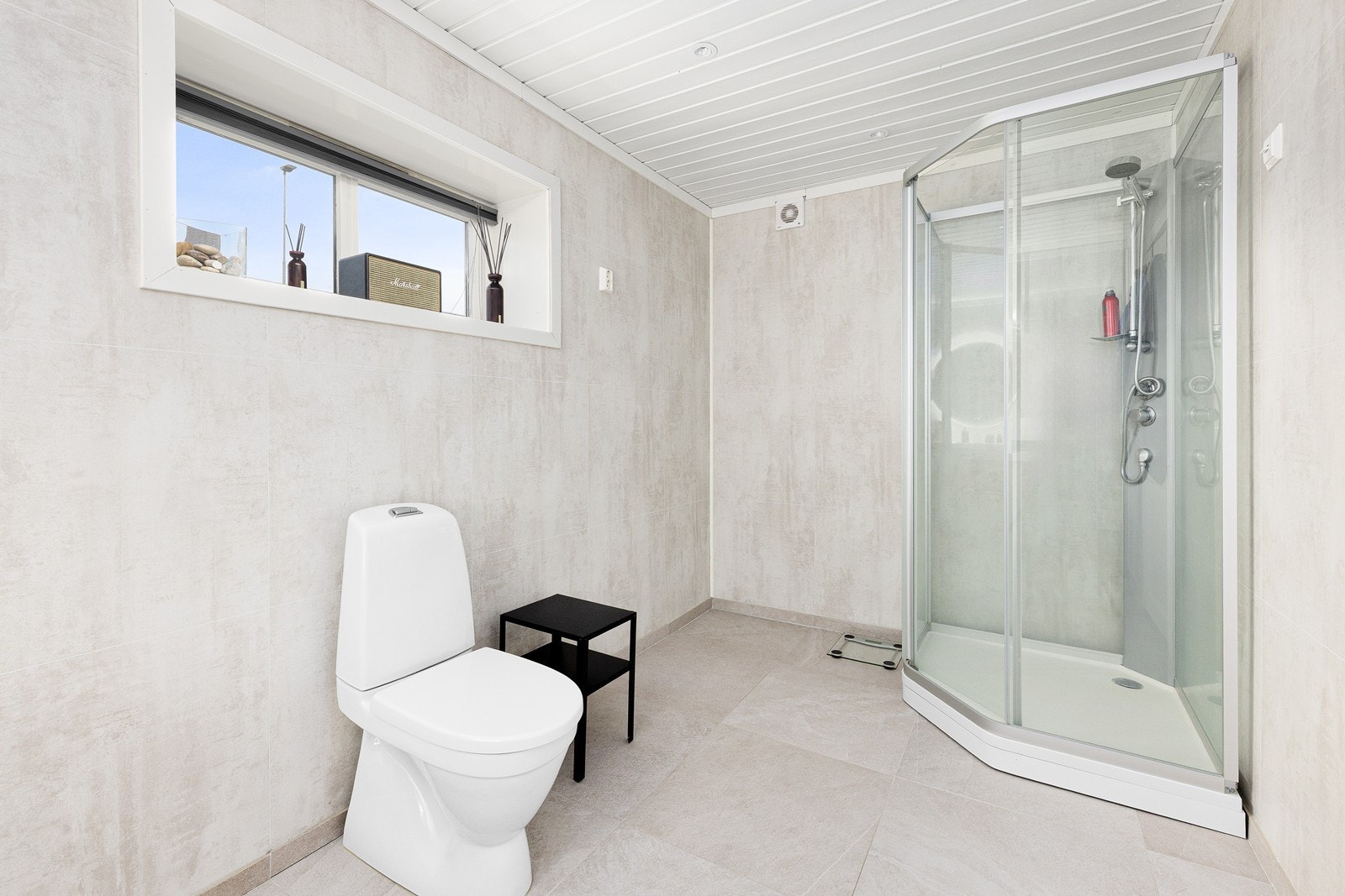 Rommet er innredet med servant i skuffeinnredning, speil med integrert belysning, dusjkabinett og toalett. Galleribilde