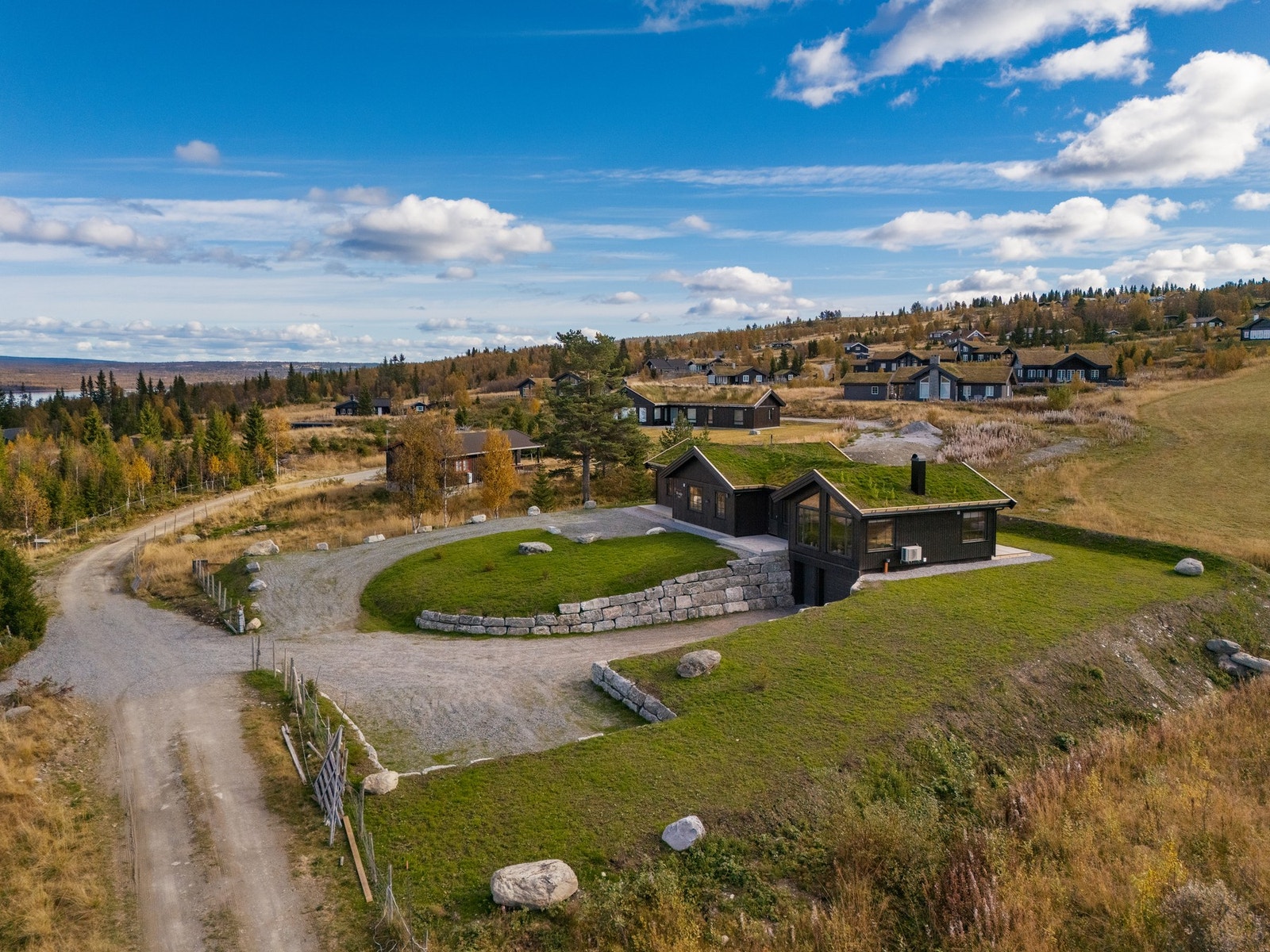 Hytta har en fin opparbeidet tomt med plen og mursteiner. God plass til flere biler. Galleribilde