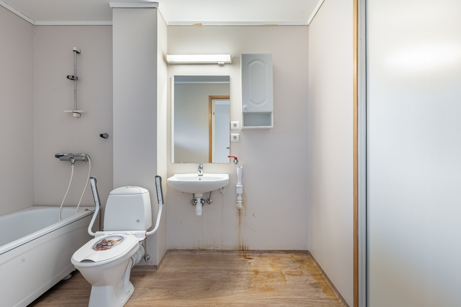 Bad med toalett, servant og badekar - rommet har opplegg for vaskemaskin Galleribilde