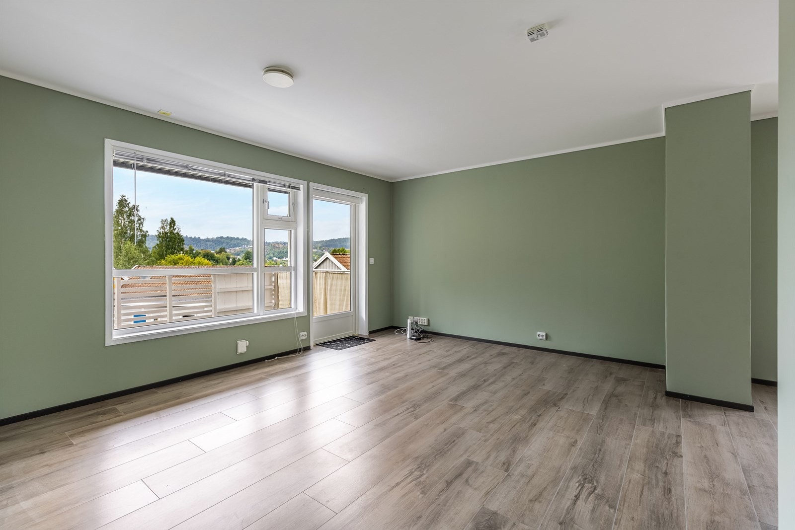 Romslig og lys stue med nyere gulv og malte overflater Galleribilde