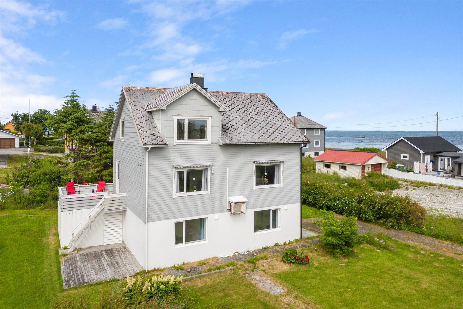 Tomten er pent opparbeidet med plen og beplantning Galleribilde