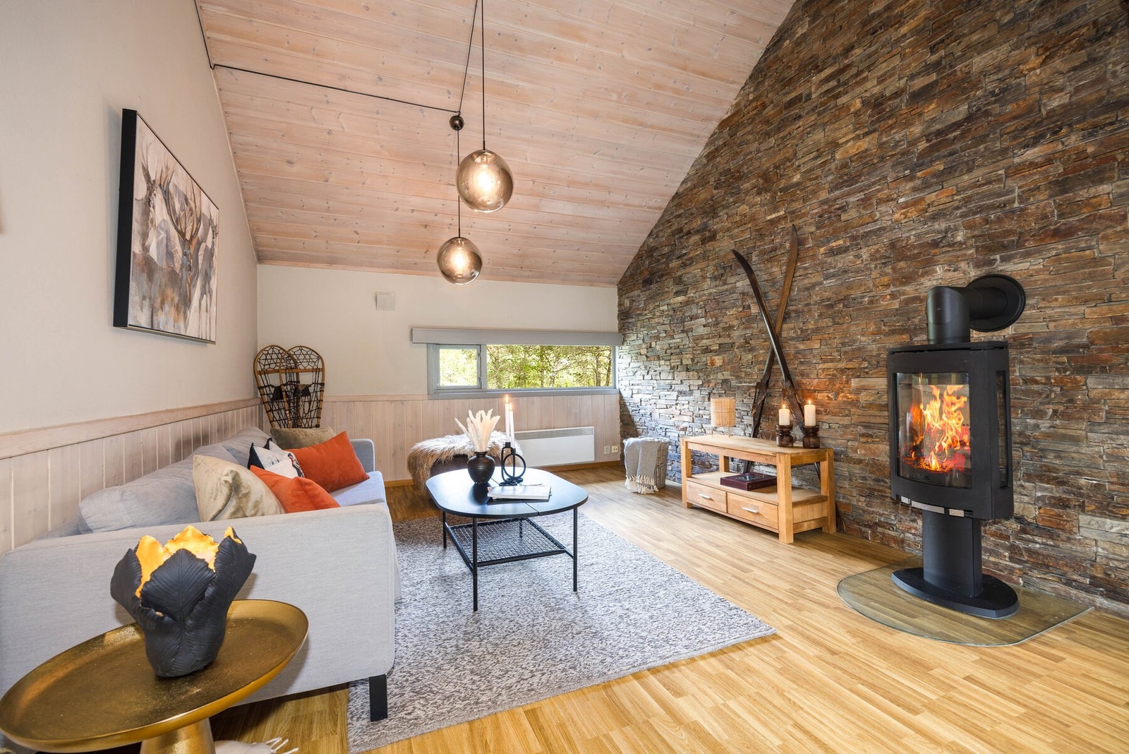 Koselig stue med moderne detaljer og en dekorativ skifervegg - her kan du nyte peiskos og fjellstemning året rundt. Galleribilde