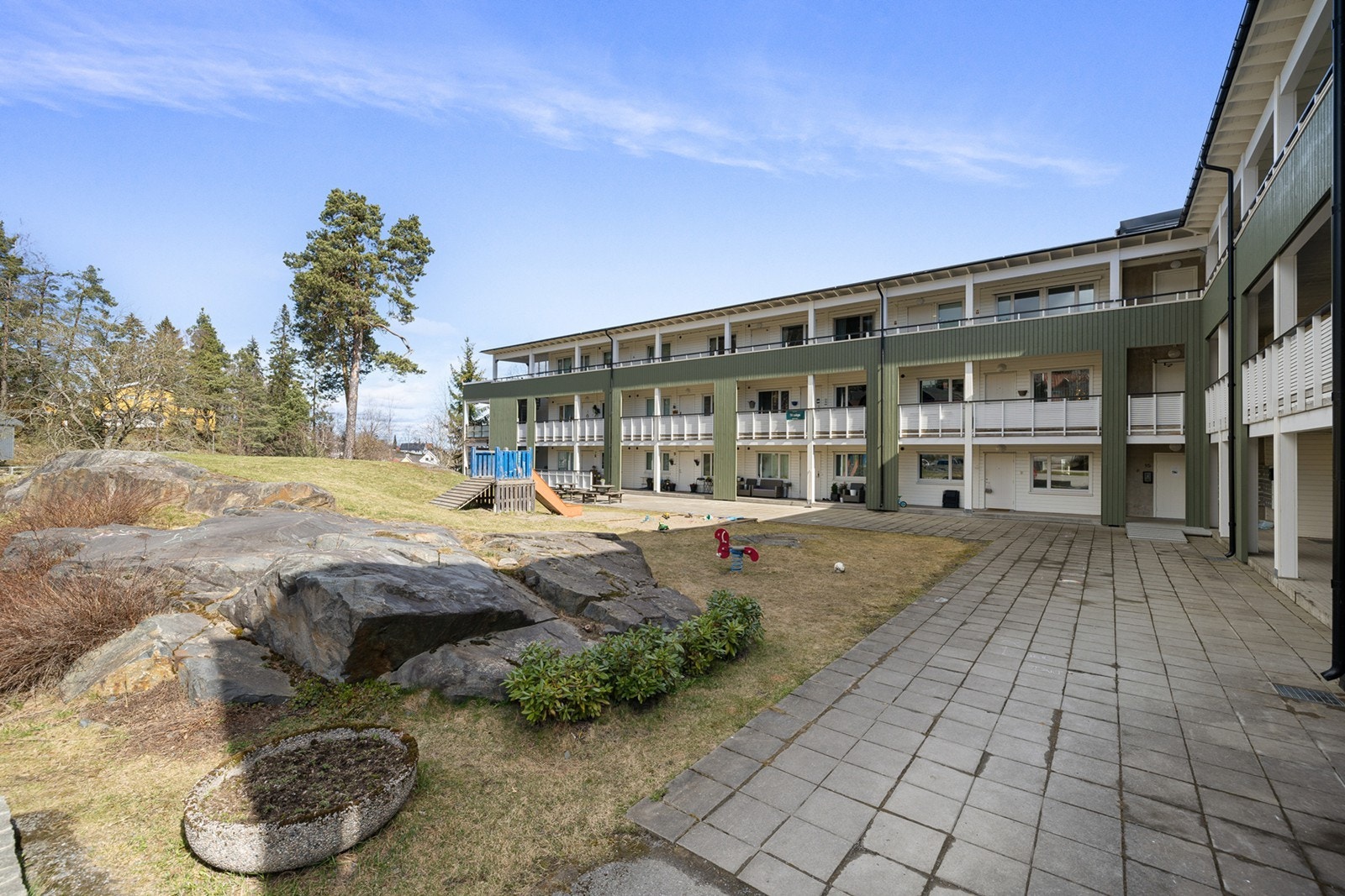 Borettslagets tomt er pent opparbeidet med grøntarealer, busker og trær. Noe naturtomt med fjell i dagen samt en lekeplass. Galleribilde