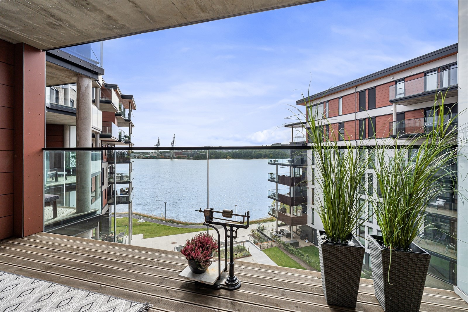 Balkongen ut fra den åpne stue/kjøkkenløsningen er overbygget og av god størrelse. Her har du anledning til en større sittegruppe og grill om du vil. Du har også god sjøutsikt fra både denne og den andre balkongen som ligger på motsatt side av leiligheten Galleribilde